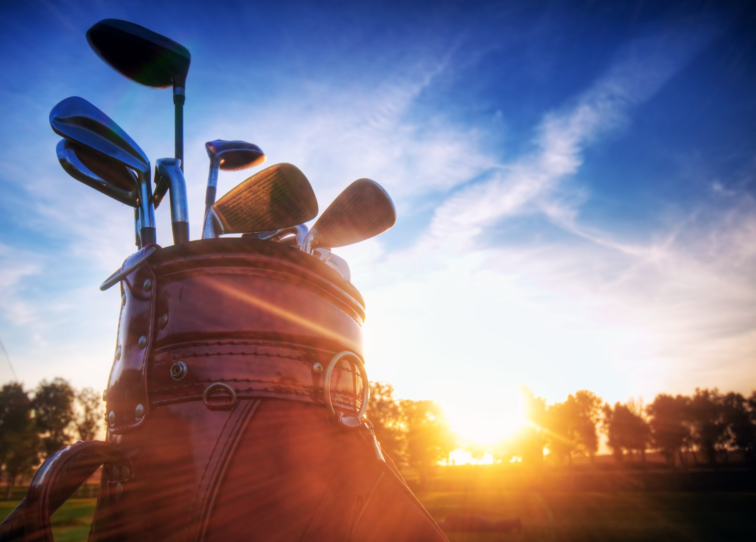 Golf gear, clubs at sunset